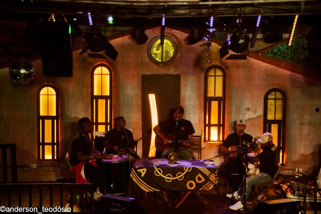 Palco da Villa do Som em noite de show com banda, globo de espelhos e iluminação cênica